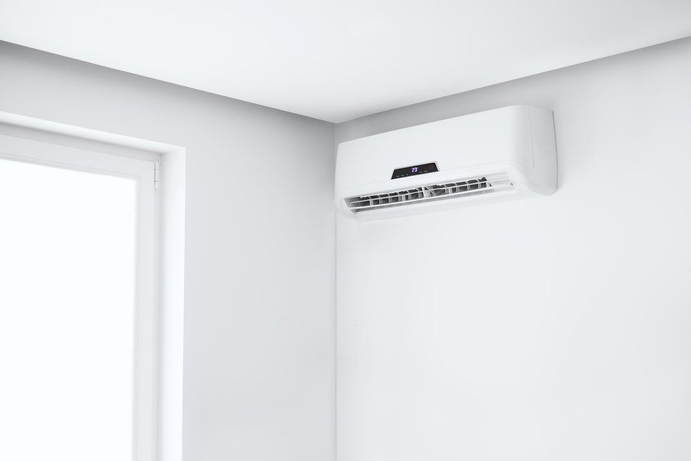 Split Air Conditioner on a White Wall — Refrigeration & Air Conditioning in Jewells, NSW
