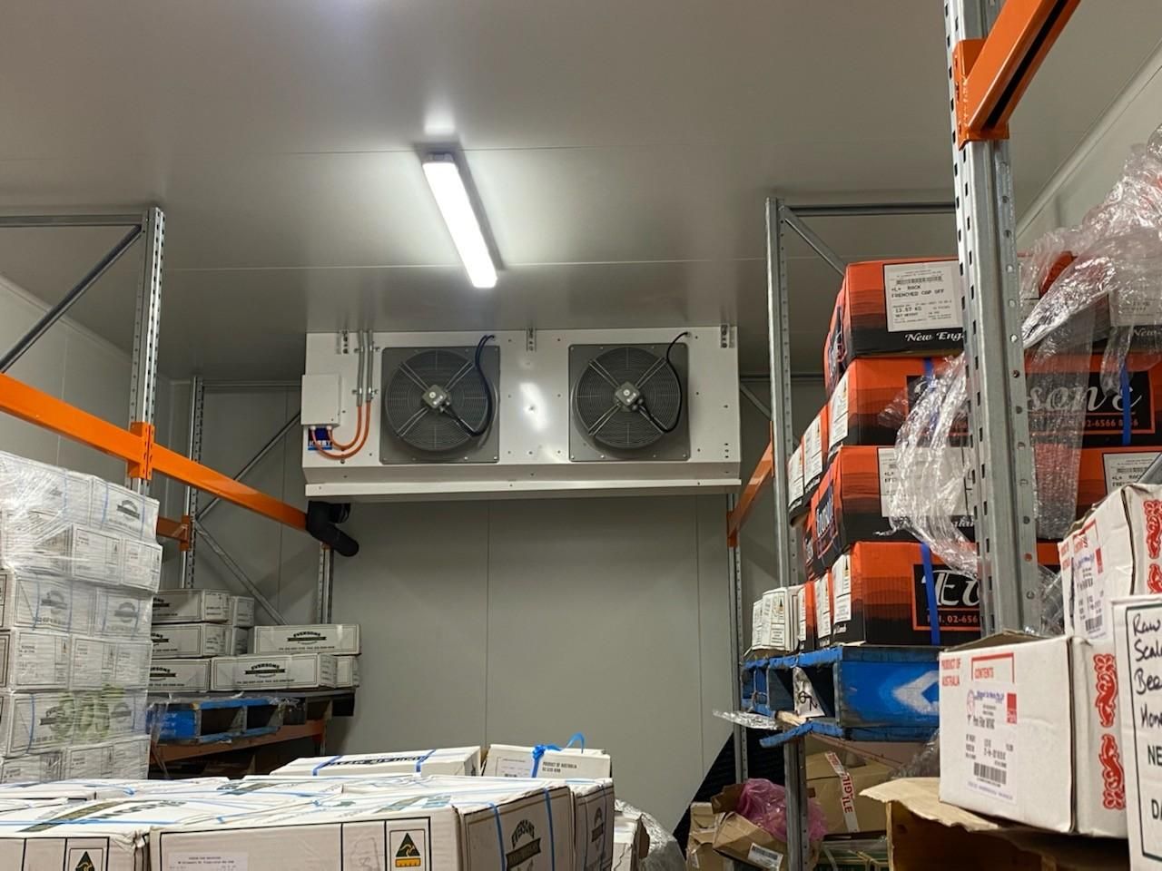 Interior of A Cold Storage Room with Stacked Boxes on Shelves — Refrigeration & Air Conditioning in Jewells, NSW