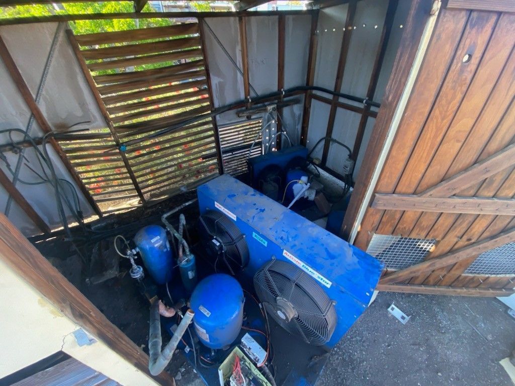Blue Industrial Equipment in A Wooden Enclosure with Slatted Walls — Refrigeration & Air Conditioning in Hunter Valley, NSW