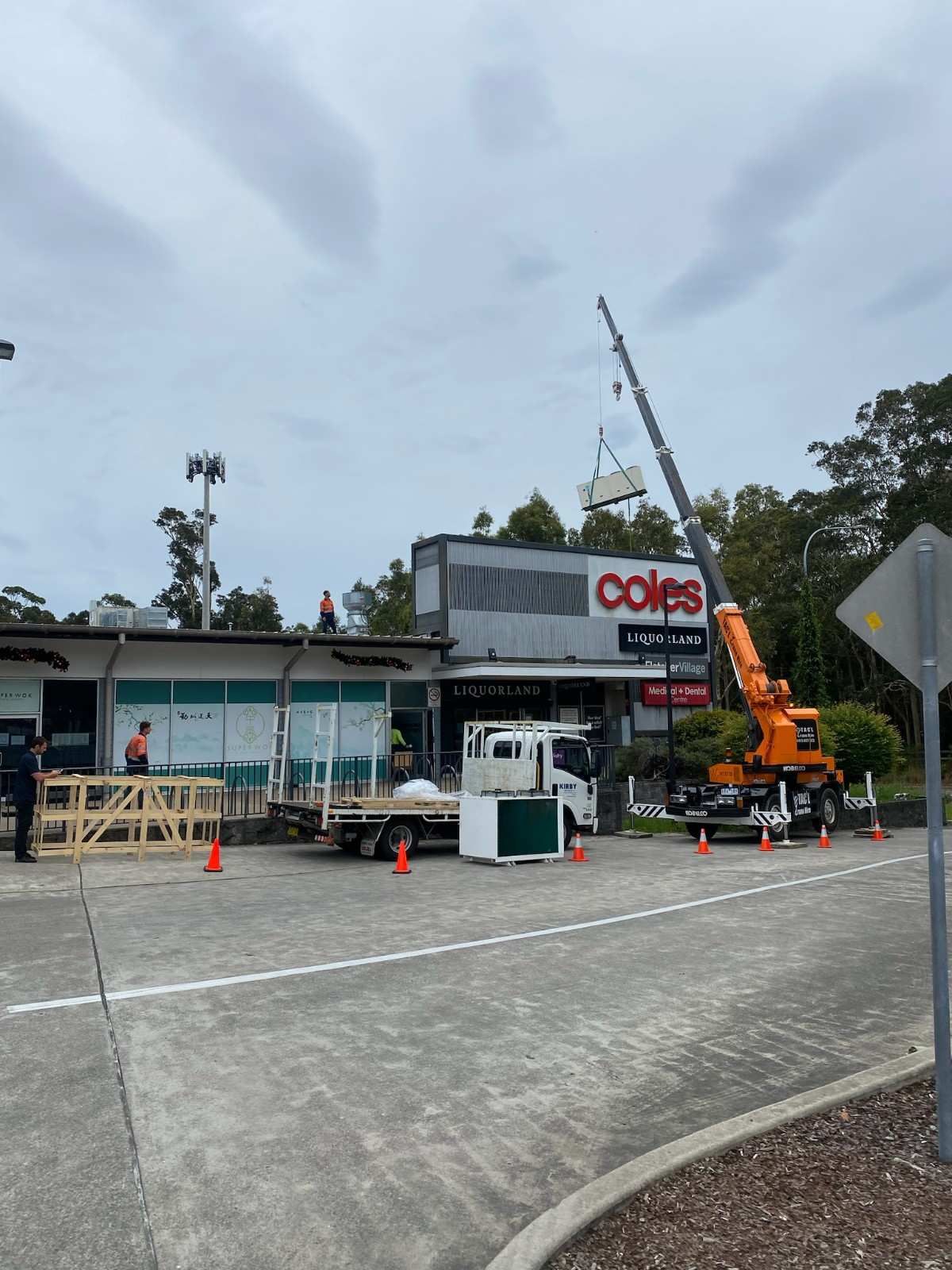 Crane Lifting Equipment Onto a Coles Supermarket Building — Refrigeration & Air Conditioning in Hunter Valley, NSW