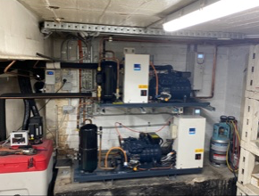 A room with a lot of electrical equipment and a red box