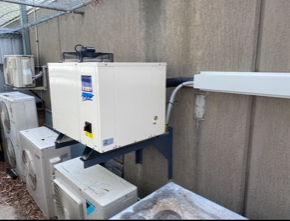 A row of air conditioners on the side of a building