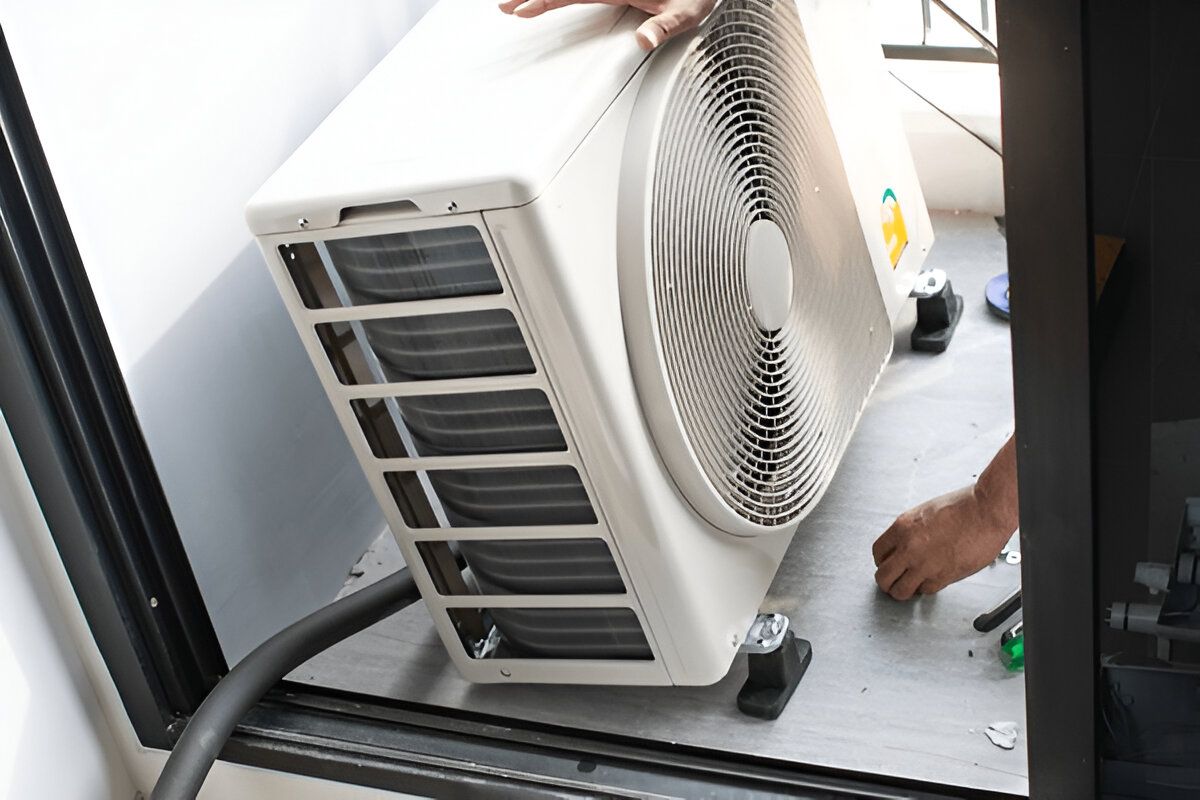 Person Installing an Air Conditioning Unit — Refrigeration & Air Conditioning in Central Coast, NSW
