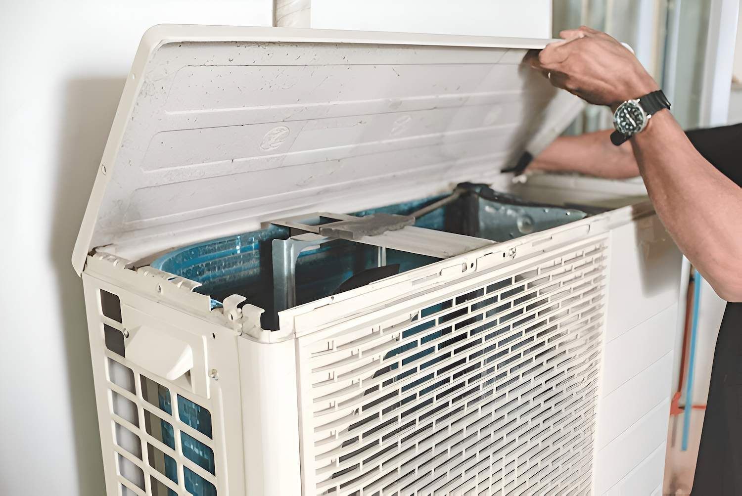 Person Opening the Top of an Outdoor Air Conditioning Unit — Refrigeration & Air Conditioning in Hunter Valley, NSW
