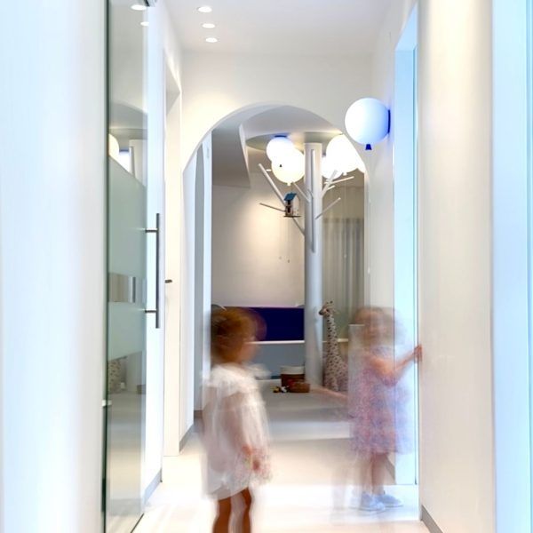 Zwei Kinder gehen durch einen weißen Flur