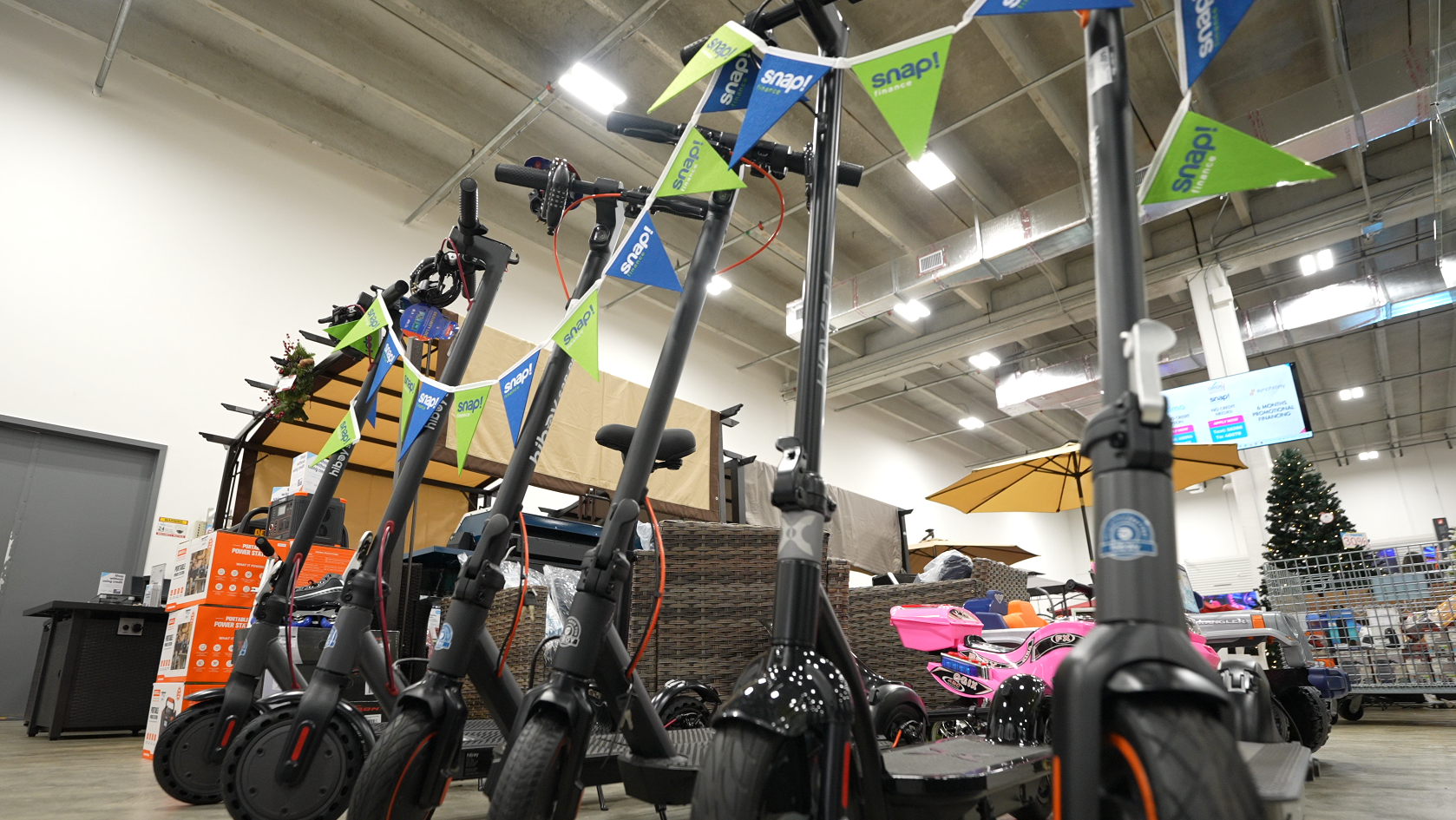 A row of electric scooters are lined up in a store.