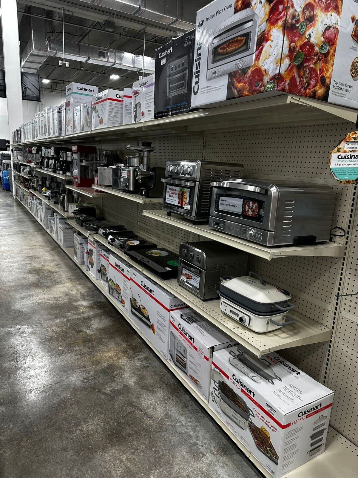 A row of shelves filled with appliances in a store.