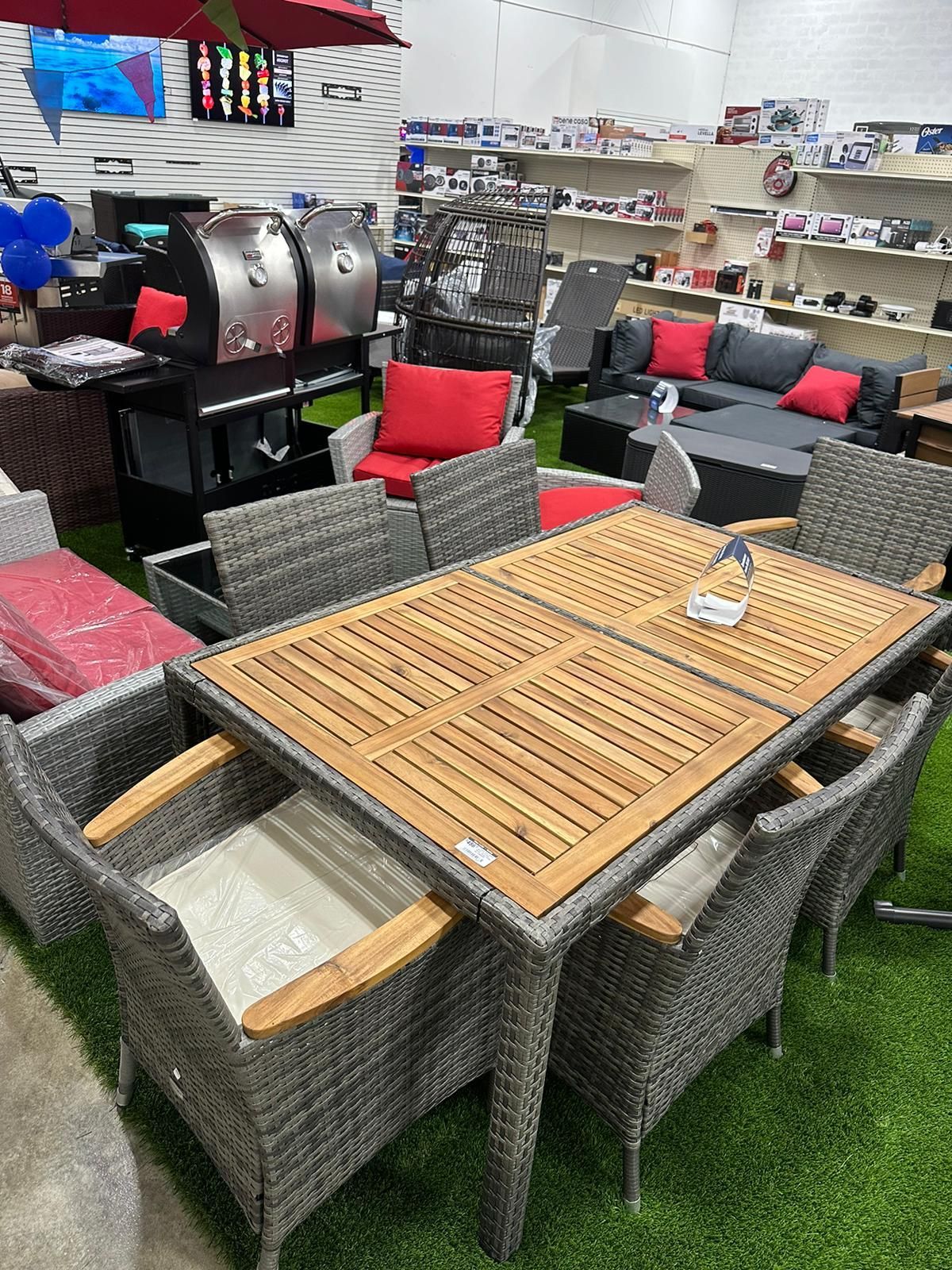 A table and chairs are sitting on top of a lush green lawn in a store.