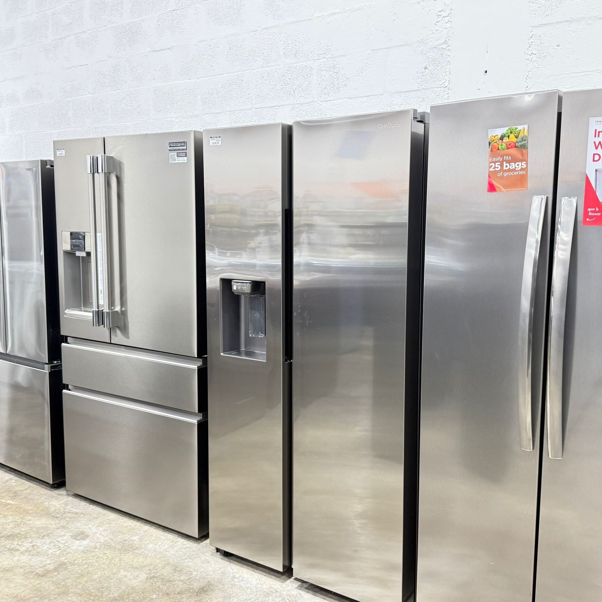A bed with gray sheets and pillows is sitting next to a potted plant.