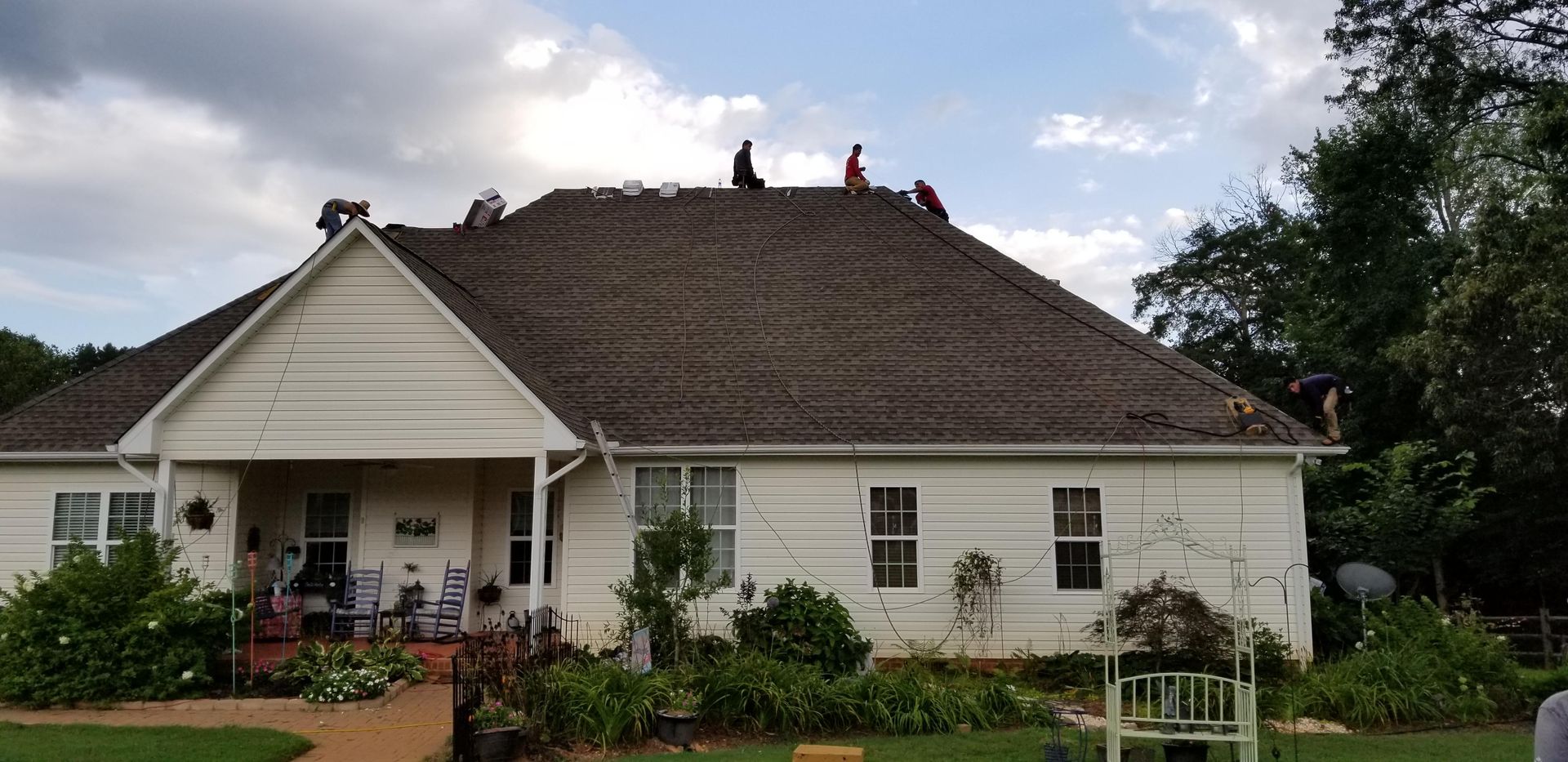 A white house with a roof that is being repaired