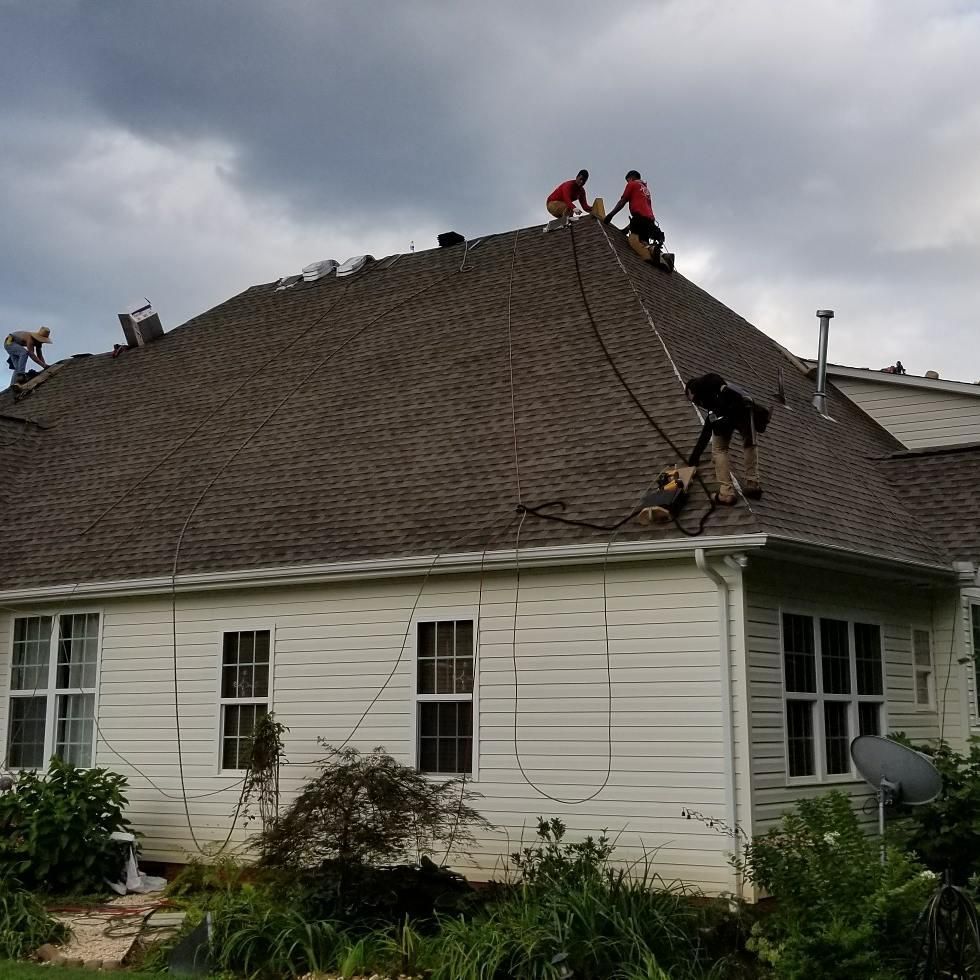 A group of men are working on the roof of a house