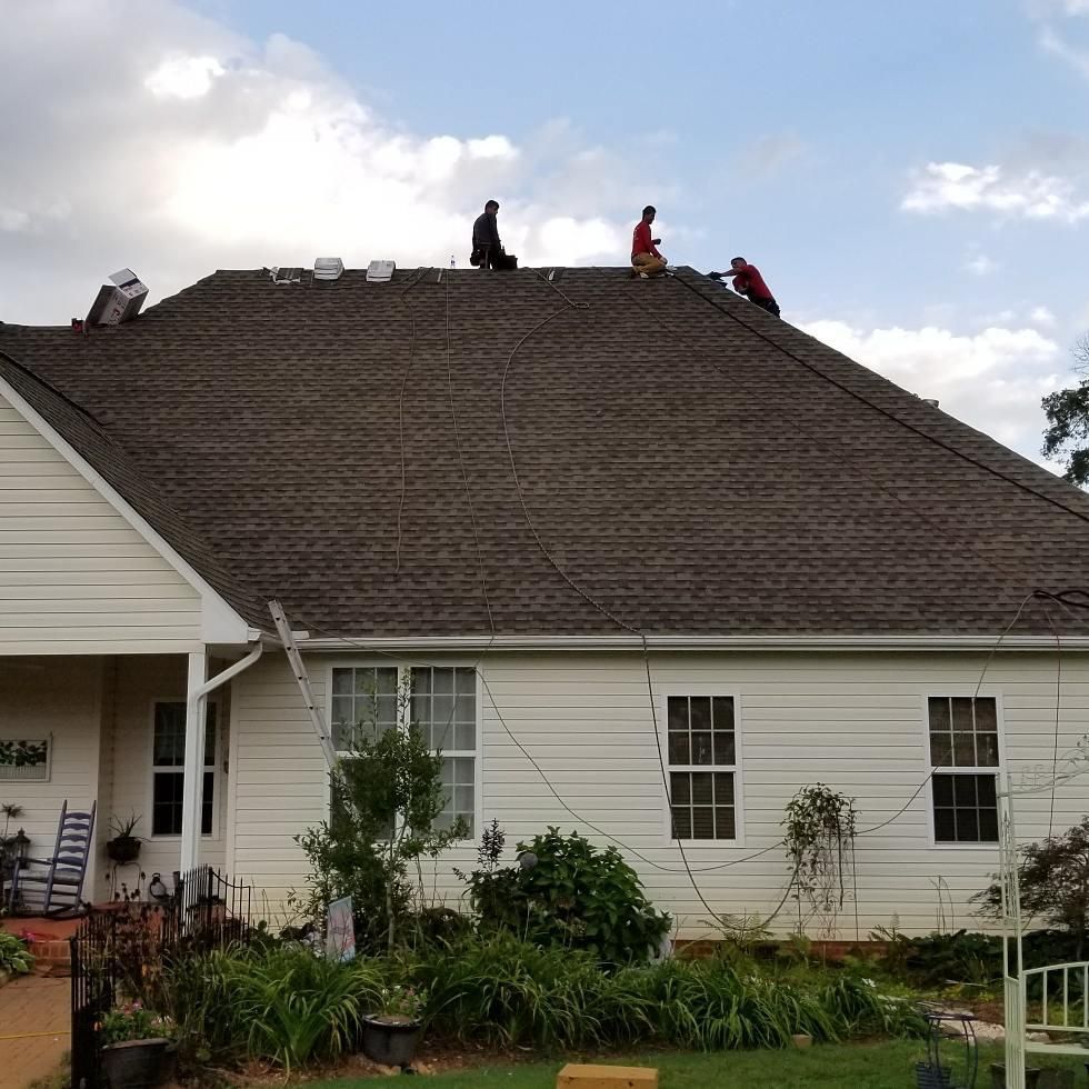 Two men are working on the roof of a house