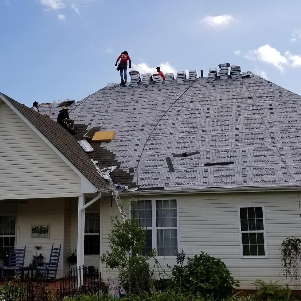 Two men are working on the roof of a house