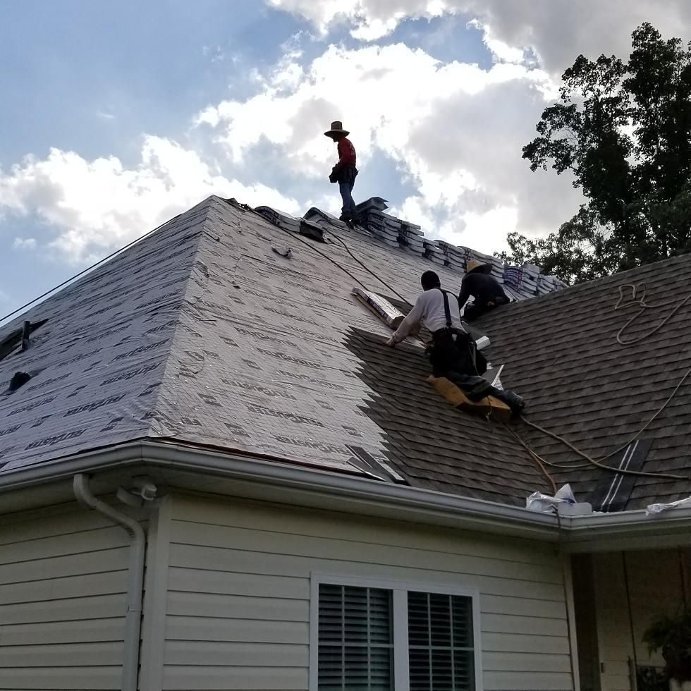 Two men are working on the roof of a house