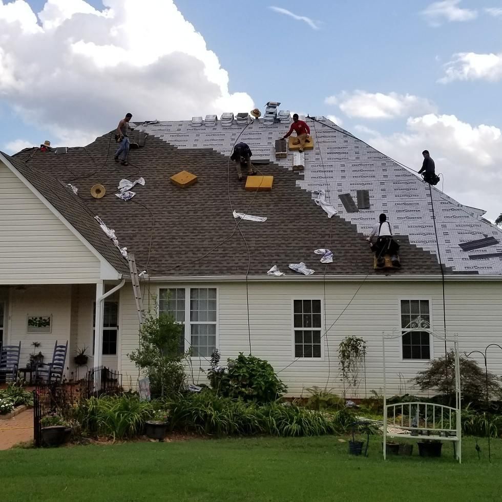 A white house with a roof that is being worked on