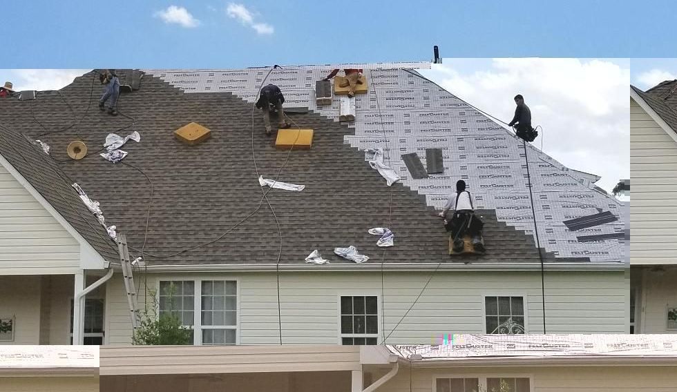 A group of people are working on a roof of a house.
