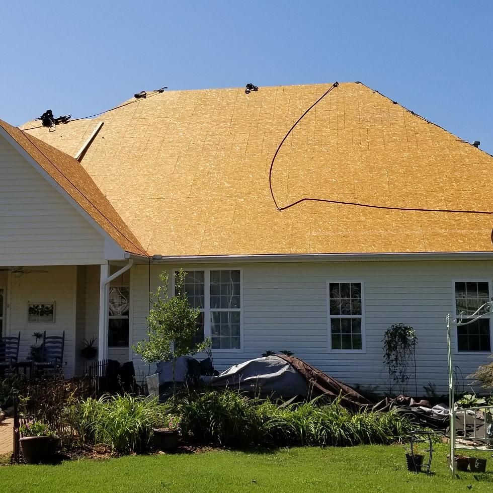 A white house with a roof that is being installed