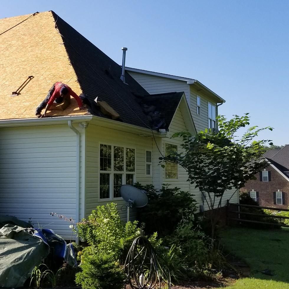 A man is working on the roof of a house