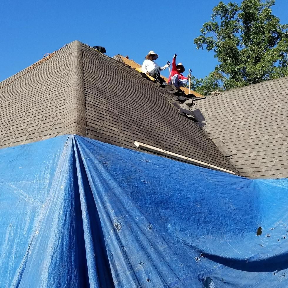 A blue tarp is covering the roof of a house