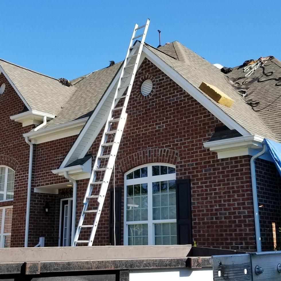 A ladder is attached to the side of a brick house
