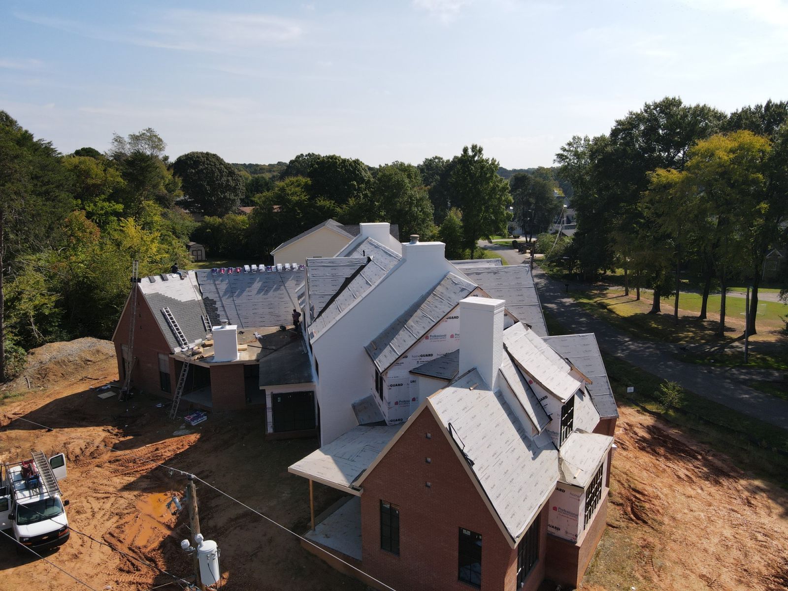 An aerial view of a house under construction surrounded by trees