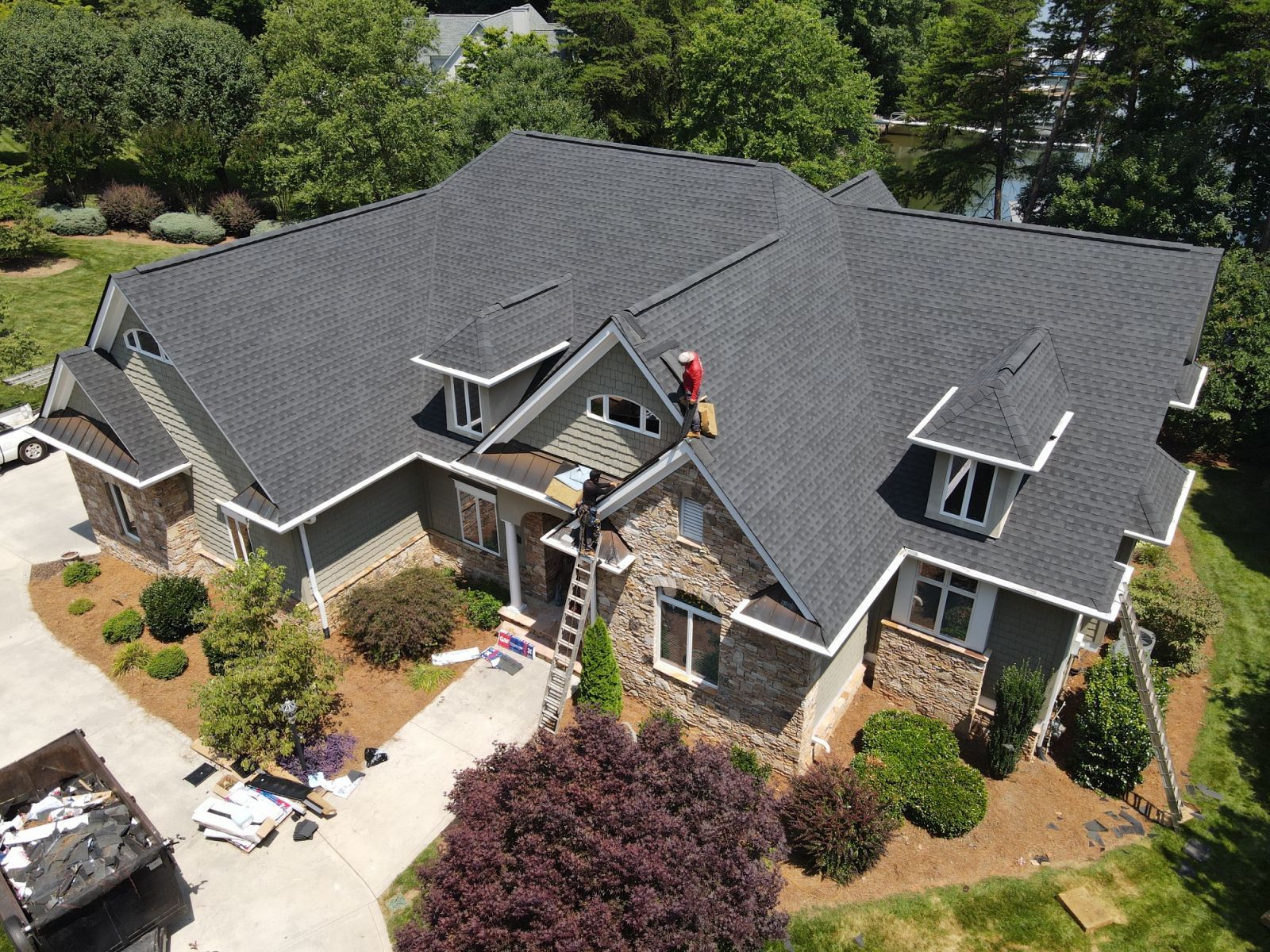 An aerial view of a large house with a roof being installed.