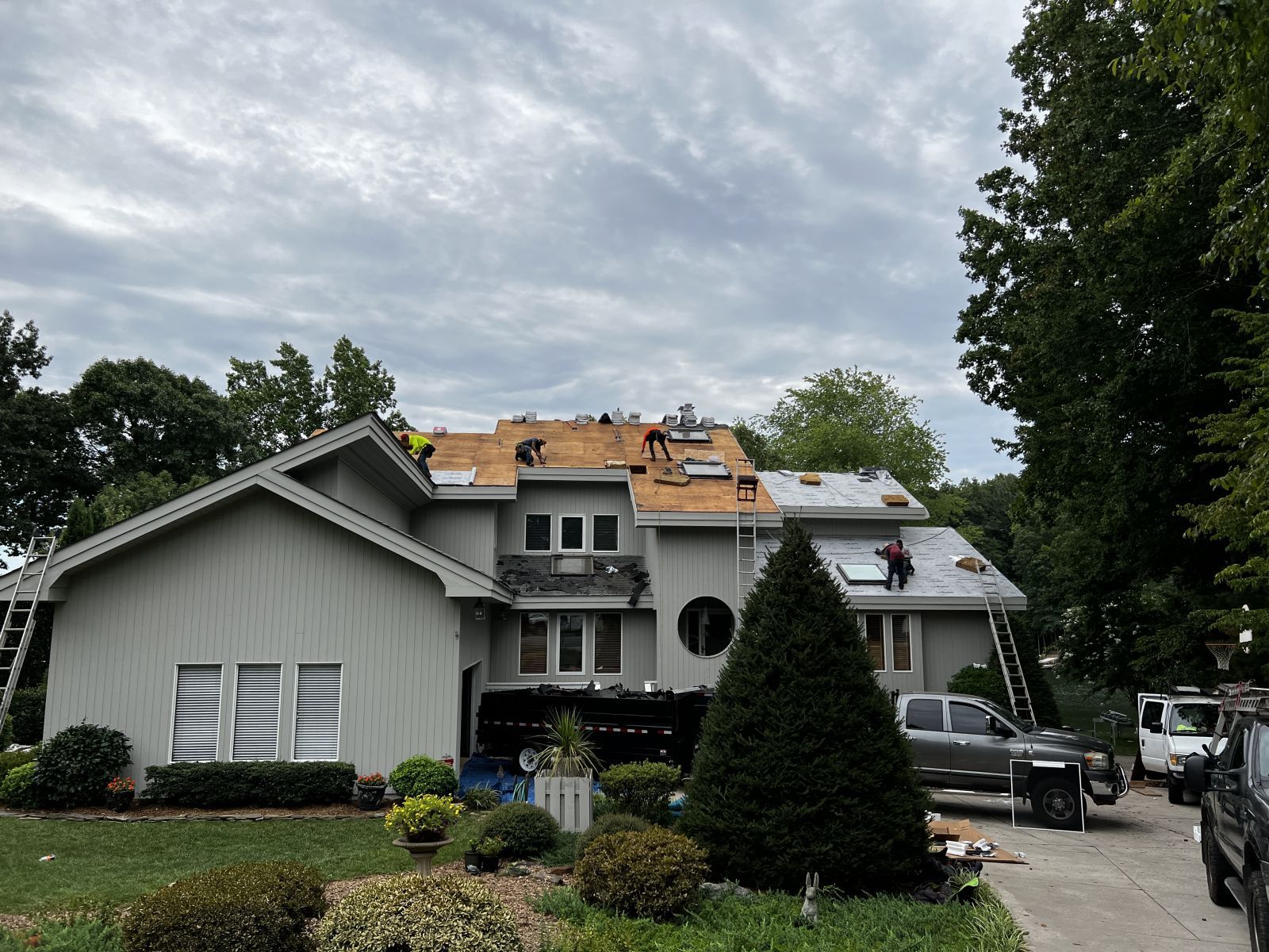 A large house is being remodeled with a roof being installed.