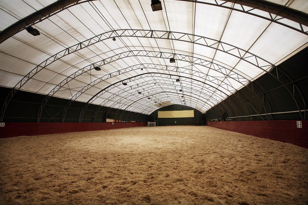 A Large Indoor Arena With A White Roof — Sunshine Coast Farrier Services In Landsborough, QLD