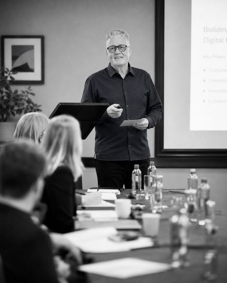 A mature website designer at Pivot2Connect is doing a presentation for a company.