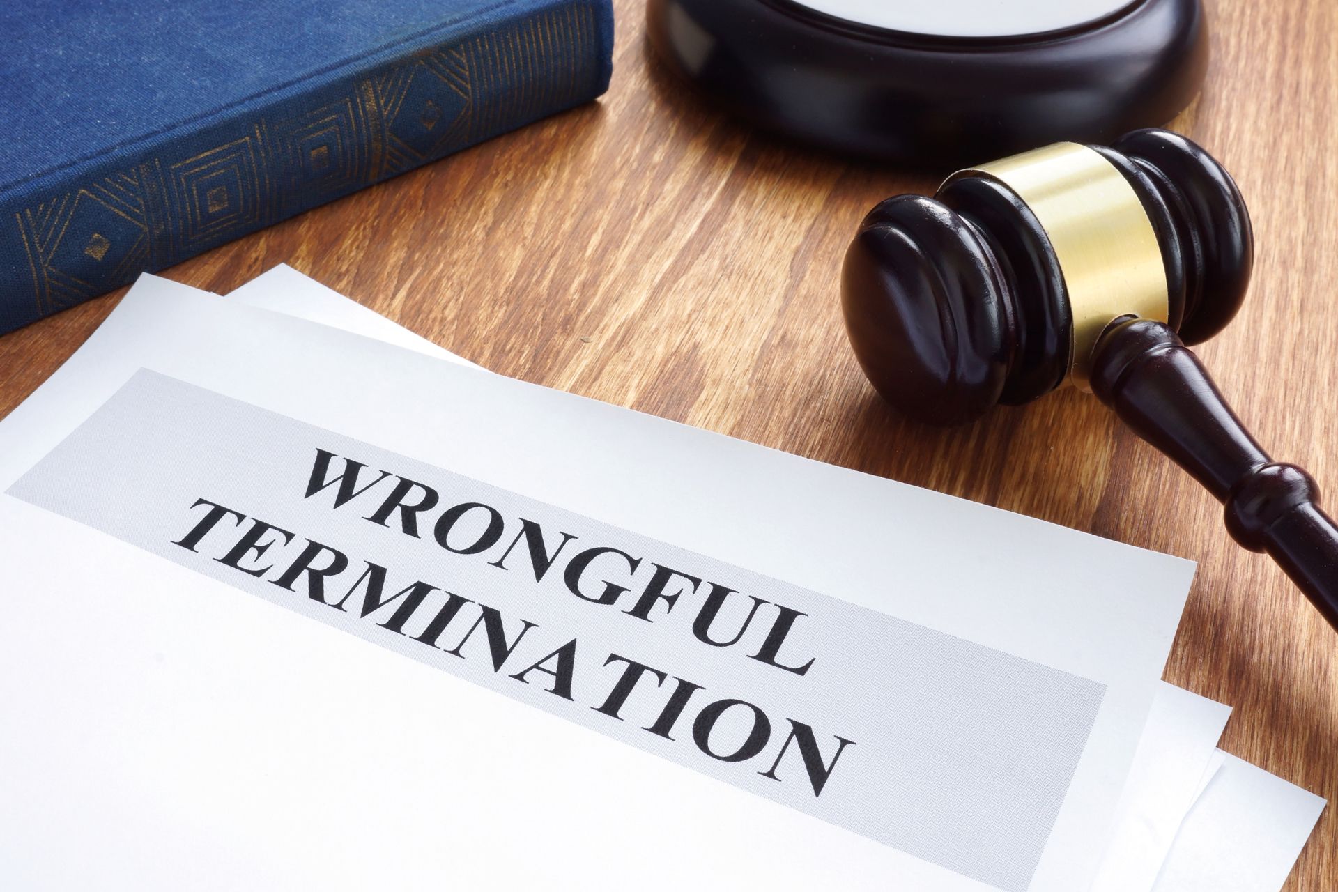 A judge 's gavel is sitting on top of a wrongful termination document