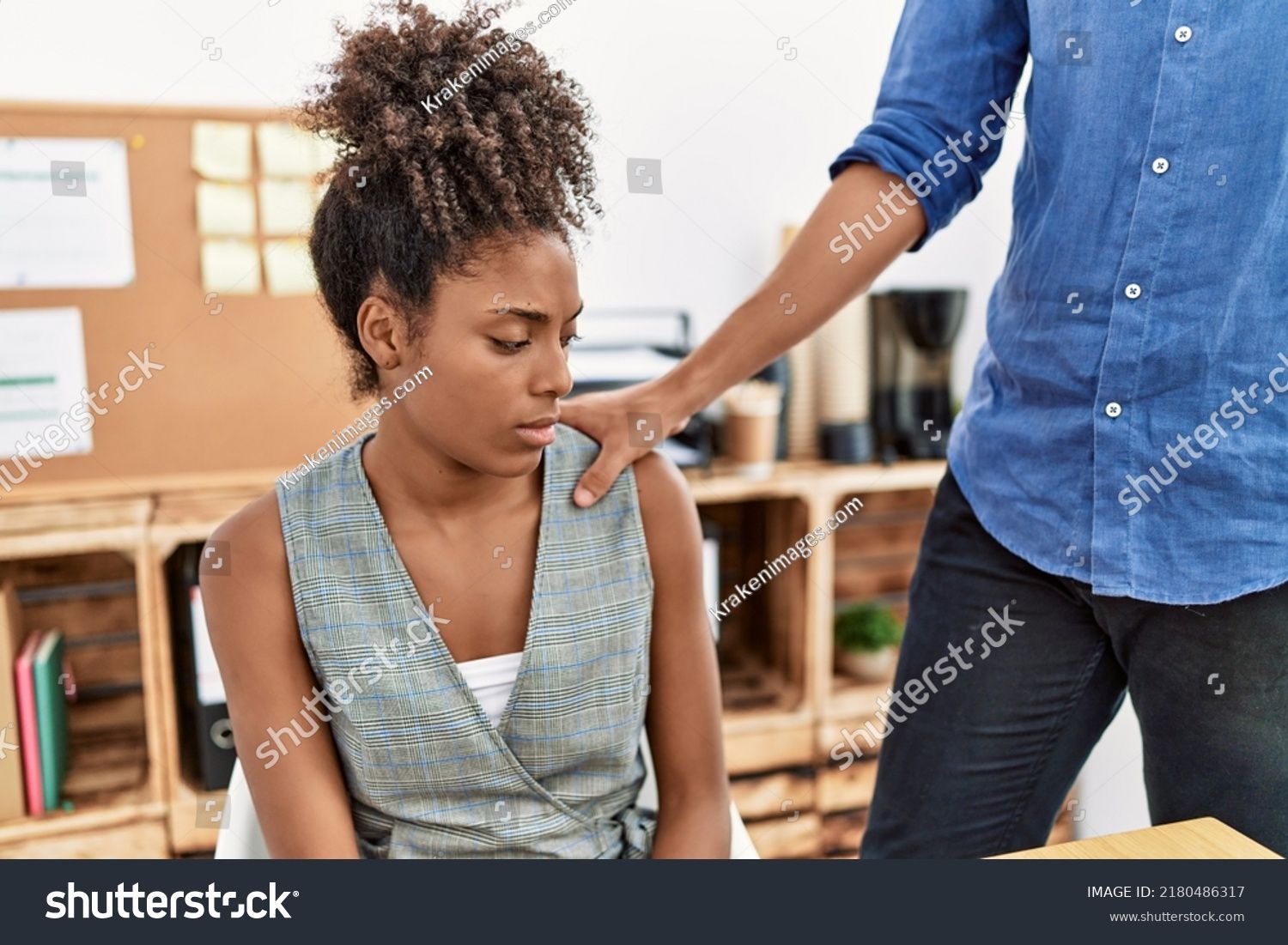 A man is putting his hand on a woman 's shoulder