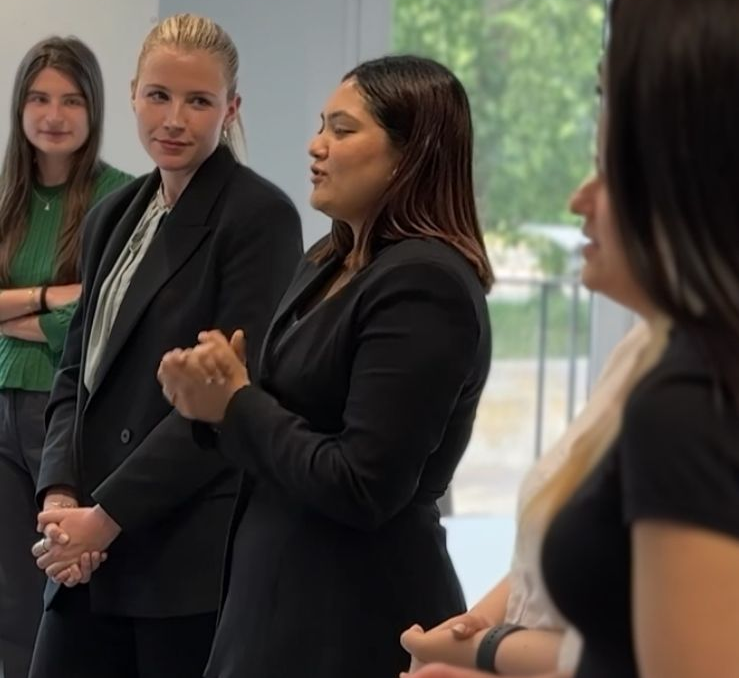 A woman is giving a presentation in front of a projector screen