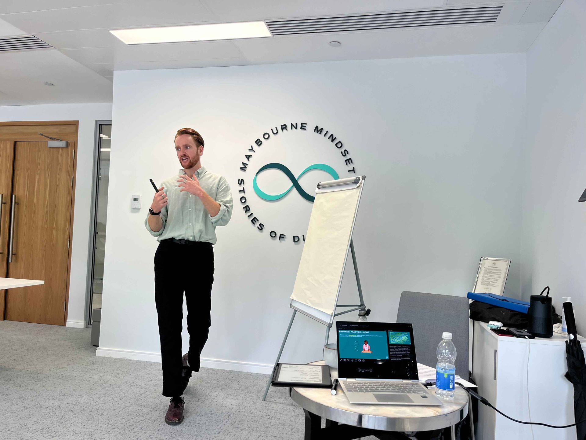 A woman is giving a presentation in front of a projector screen