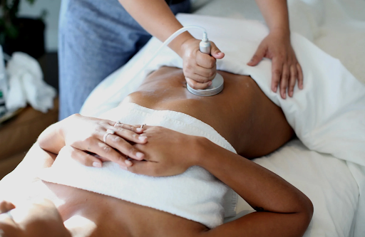 Person receiving a foot massage on a massage table indoors.
