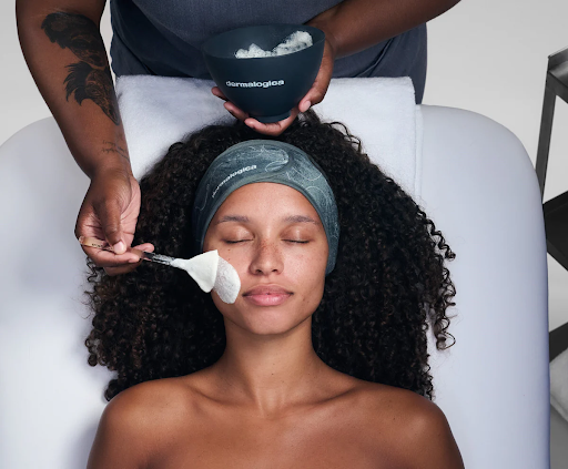 Beautician giving facial treatment to a client in a spa.