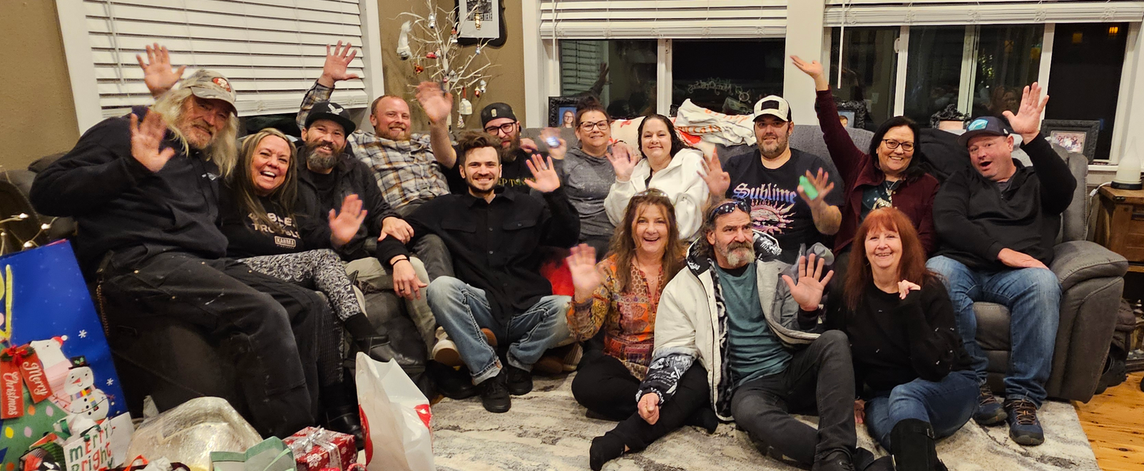 Group of people on including technicians and office staff at Niemen Glass company waving at the camera