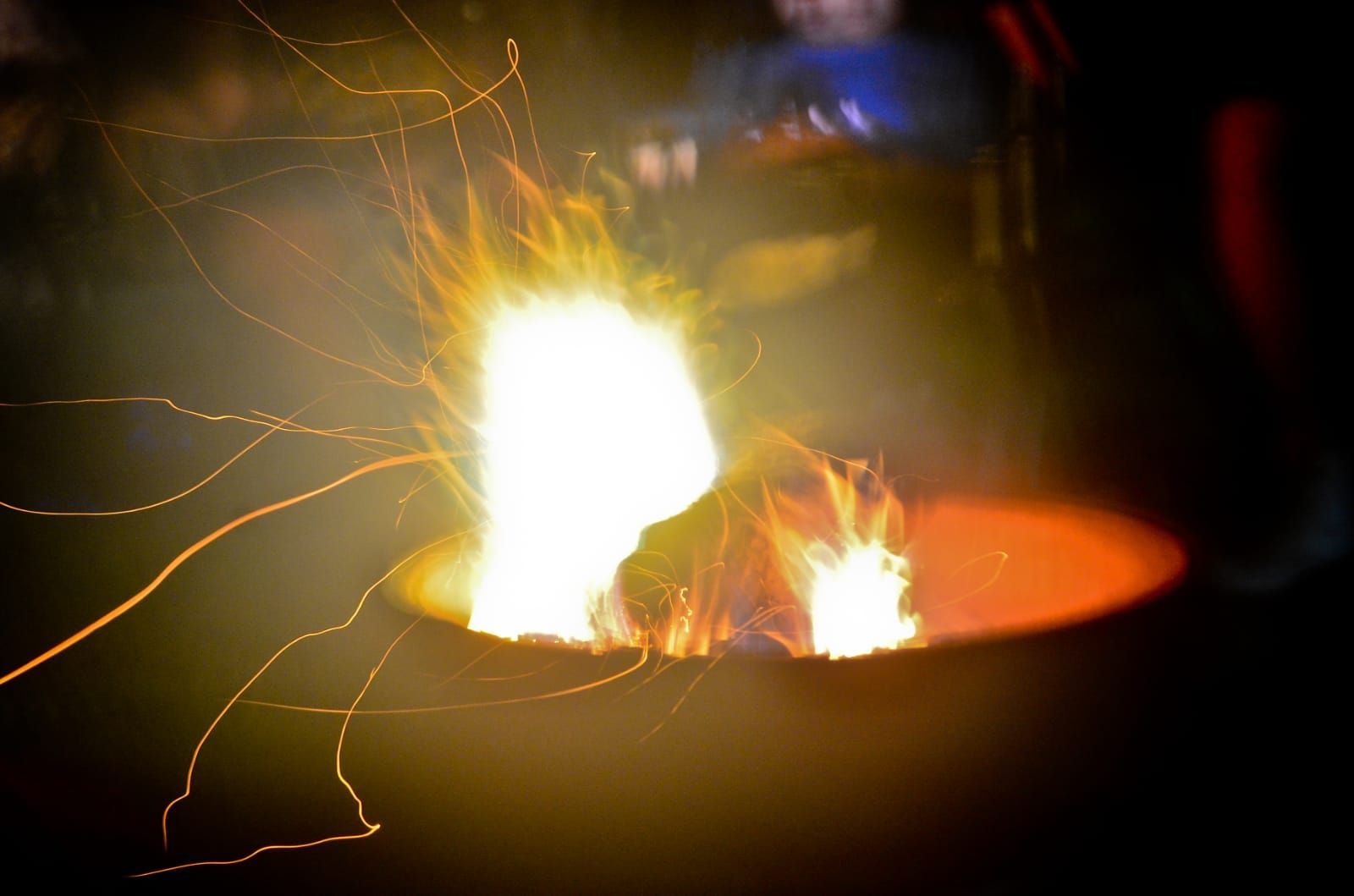 A camp fire burns in a barrel