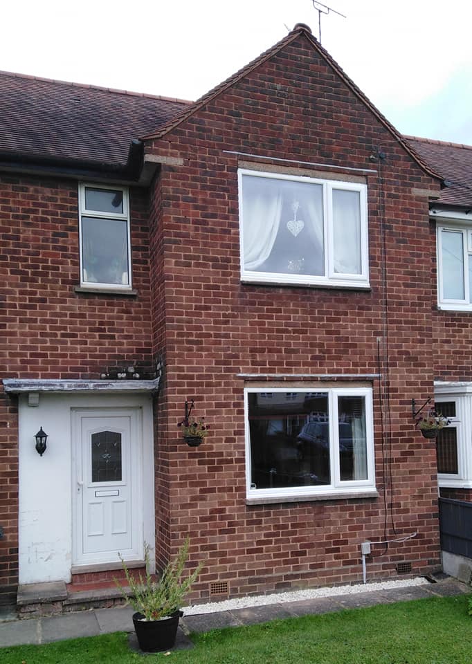 a brick house with a white door and windows