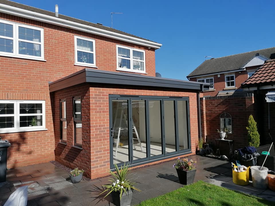 a brick house with a sliding glass door in the backyard .