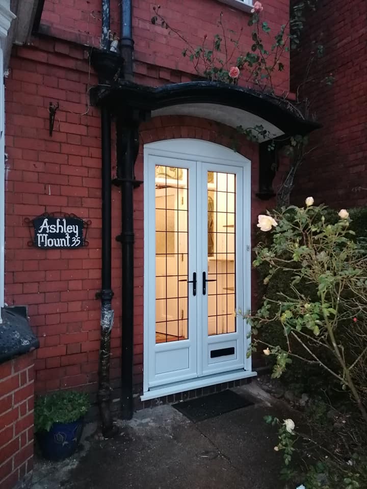 a brick building with a white door and a sign that says ashley wood