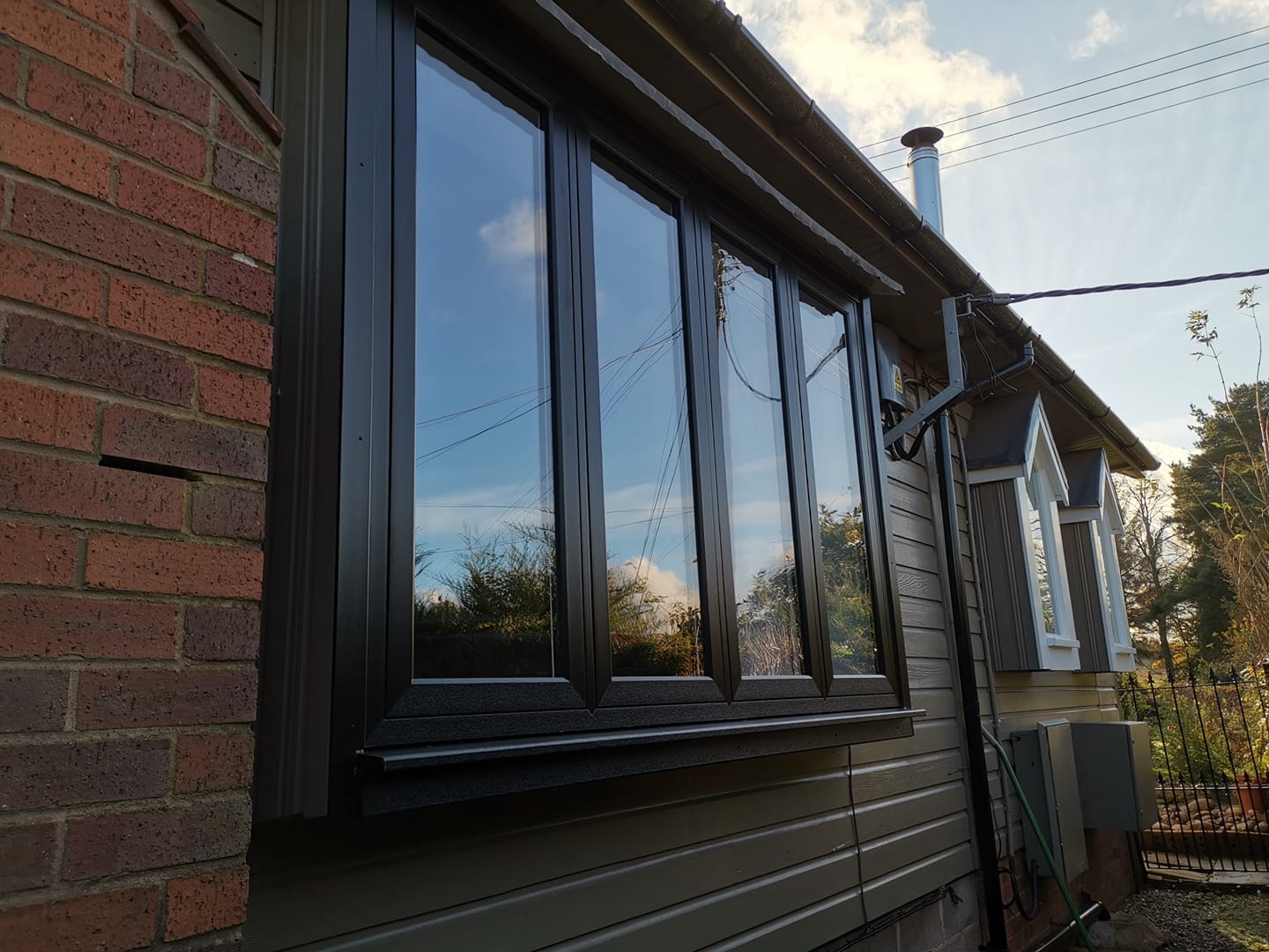 a brick house with a black window on the side of it .