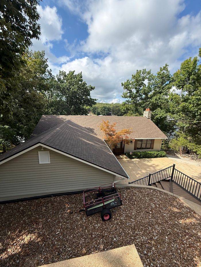 Hat with a brown leather patch, gray and black fabric, sitting on a brown table.