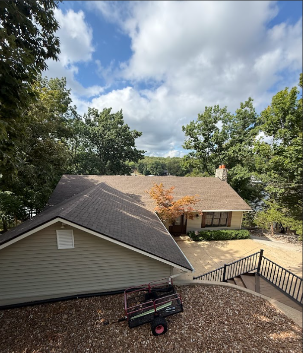 View of a lake and bridge from an open-air balcony under a roof.