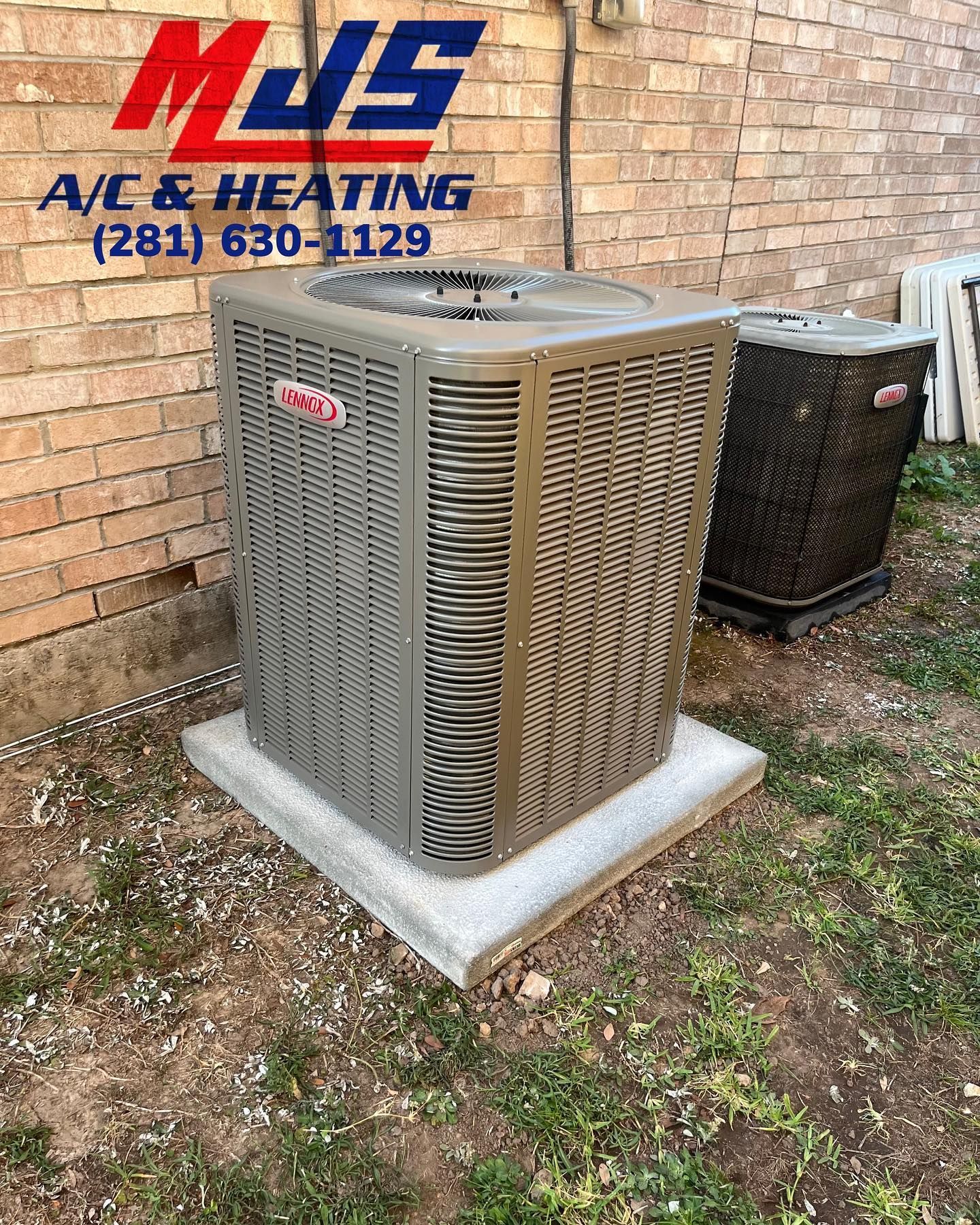 An air conditioning unit sits on a concrete pad near a brick wall, with the logo for MJS A/C & Heating in the upper left corner.