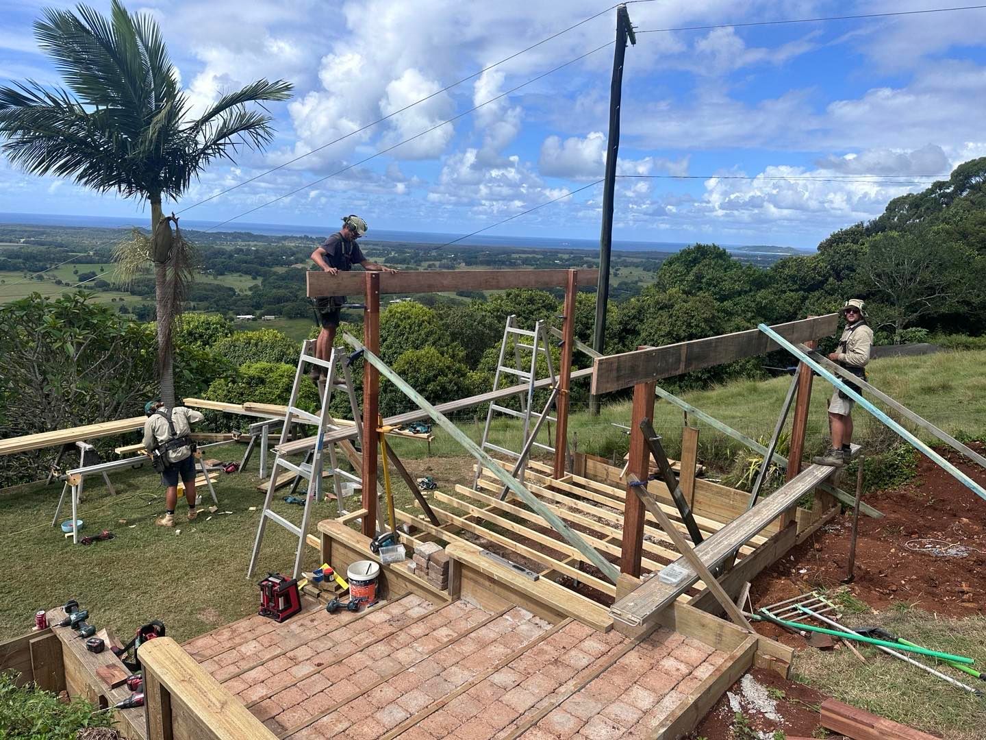 A Group Of People Are Working On A Wooden Structure In A Field — JC Coastal Construction In Coorabell, NSW