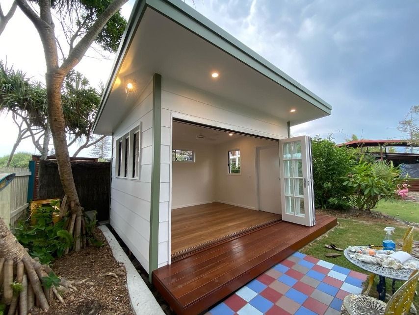A Small White House With A Wooden Deck In The Backyard — JC Coastal Construction In Coorabell, NSW