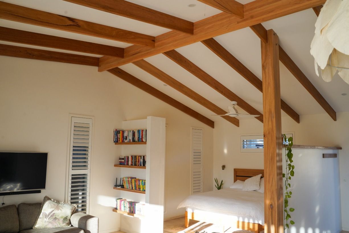 A Living Room With Wooden Beams And A Bed — JC Coastal Construction In Coorabell, NSW