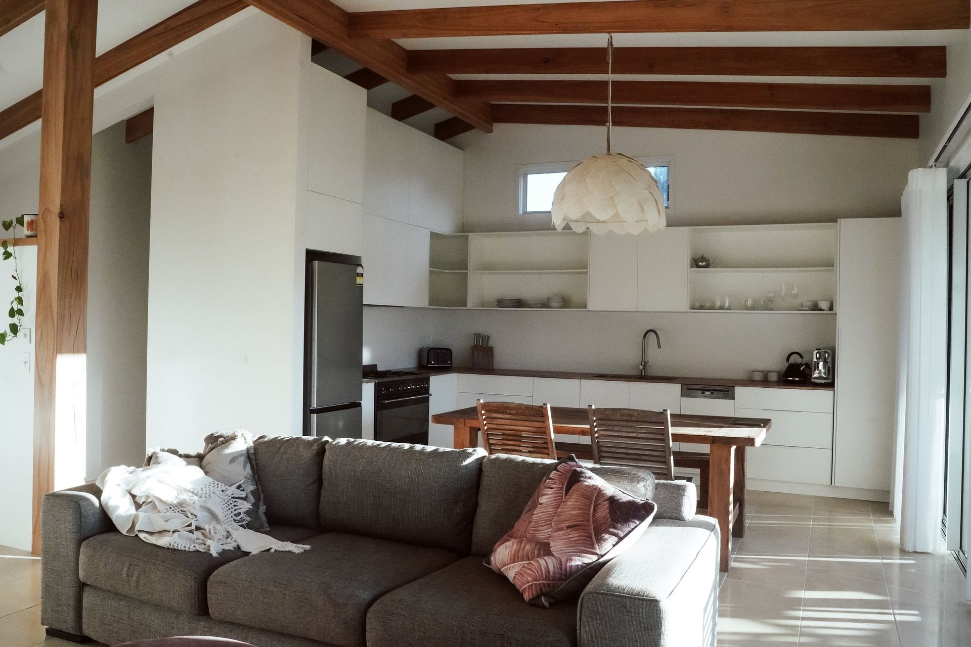 A Living Room With A Couch And A Kitchen In The Background — JC Coastal Construction In Lismore, NSW