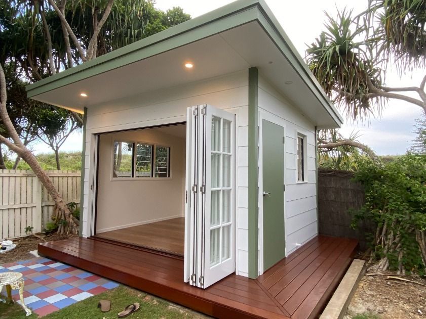 A Small White House With A Green Roof And A Wooden Deck — JC Coastal Construction In Lennox Head, NSW