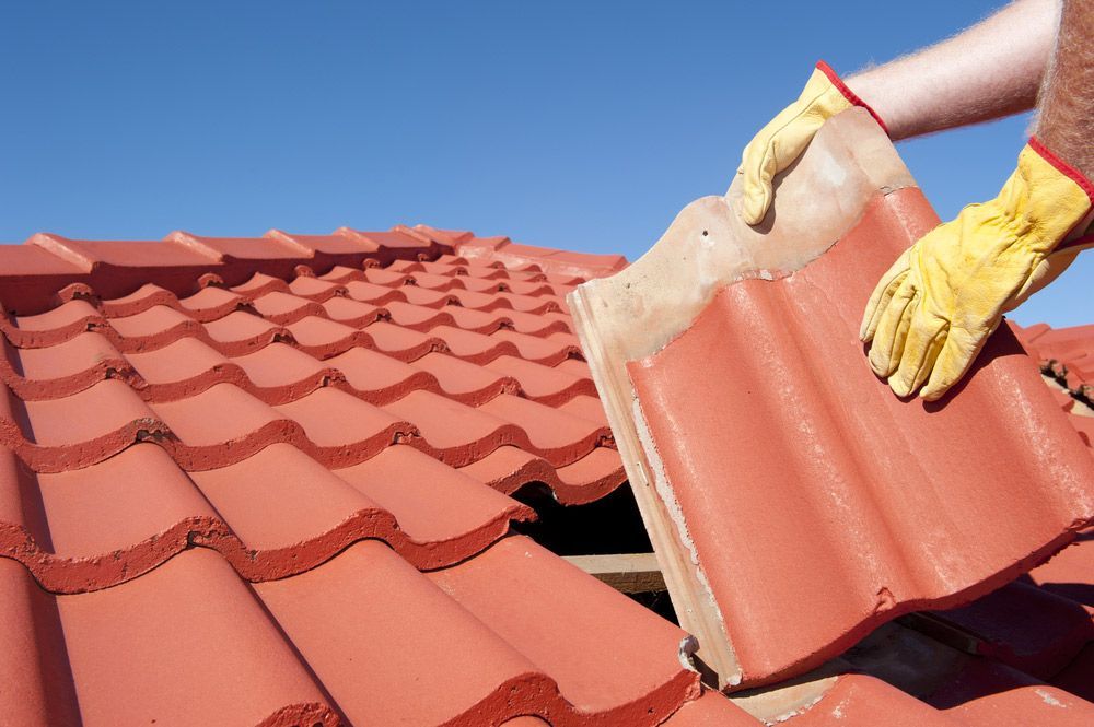 Man Fixing Red Roof Tile — Roofing In Ballina, NSW